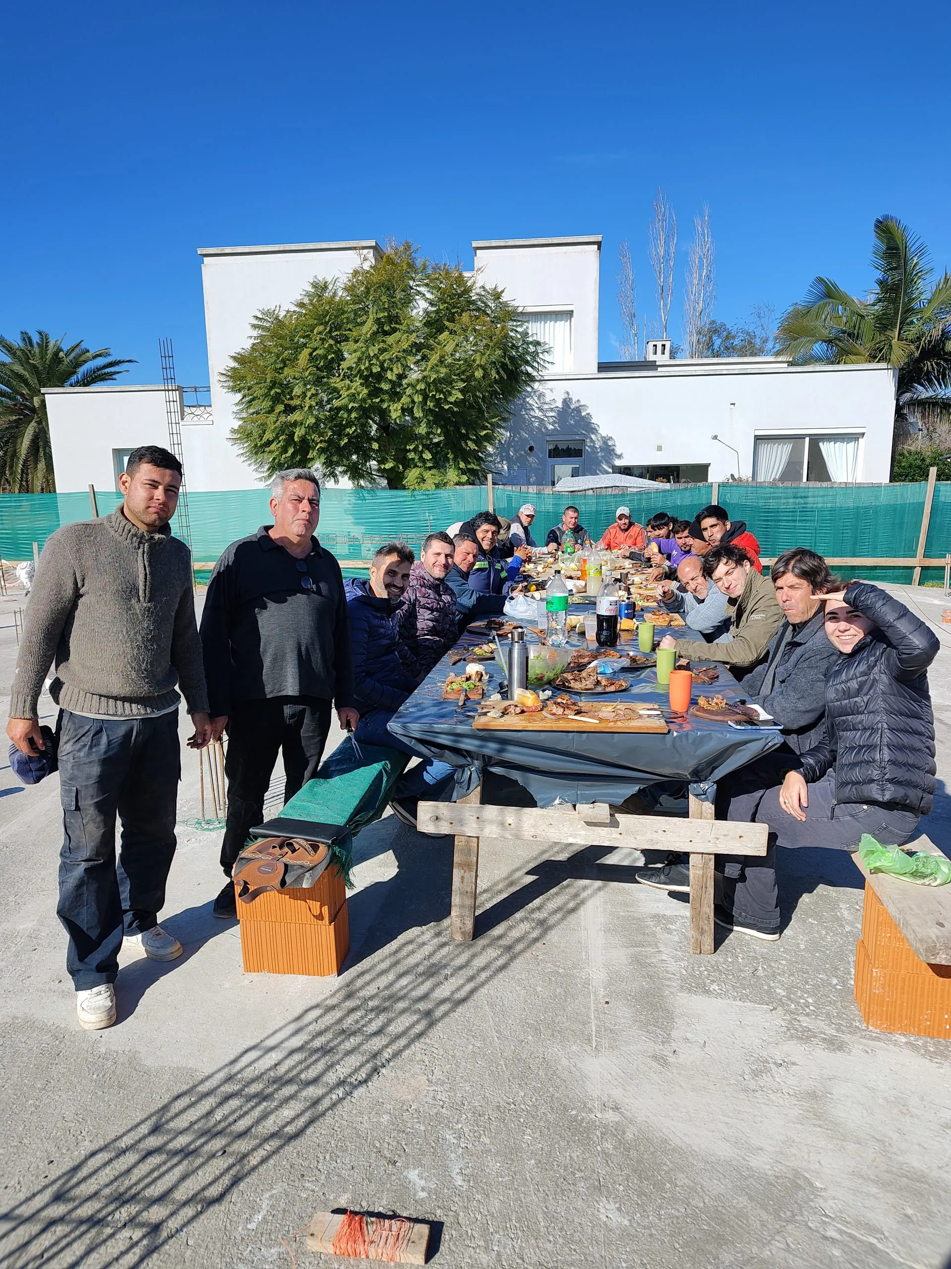 El equipo del estudio compartiendo un asado sobre la losa de una obra en construcción
