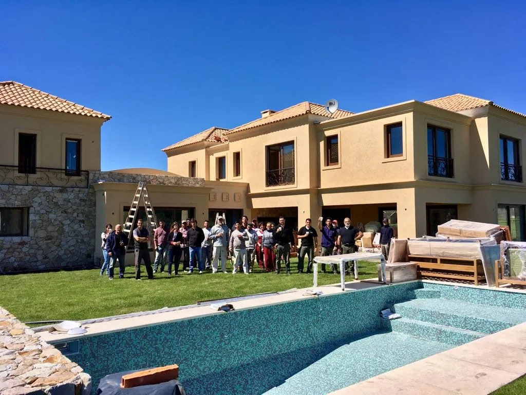 El equipo del estudio en una obra en construcción, frente a la casa y la pileta todavía en obra