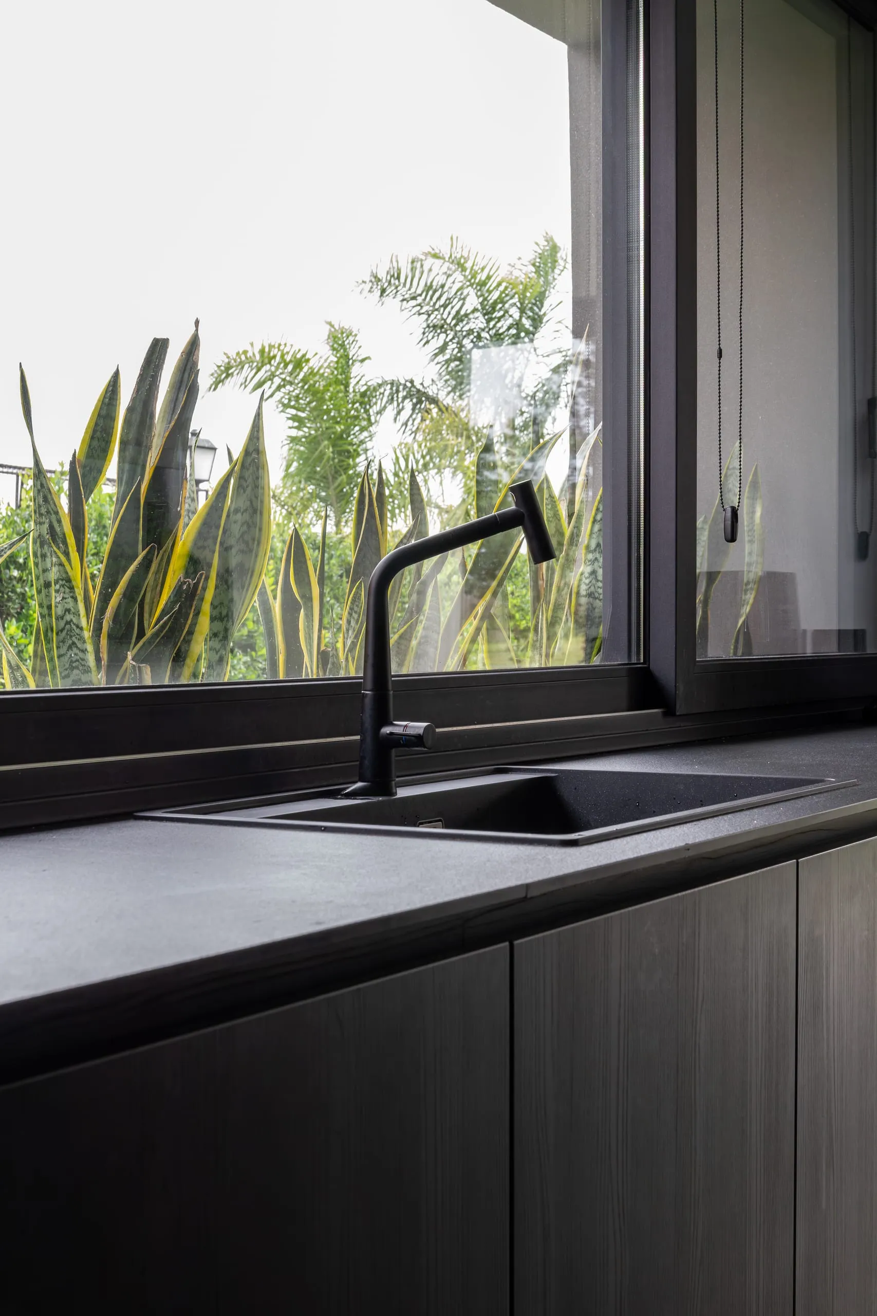 Bacha de la cocina junto a la ventana, con mesada negra