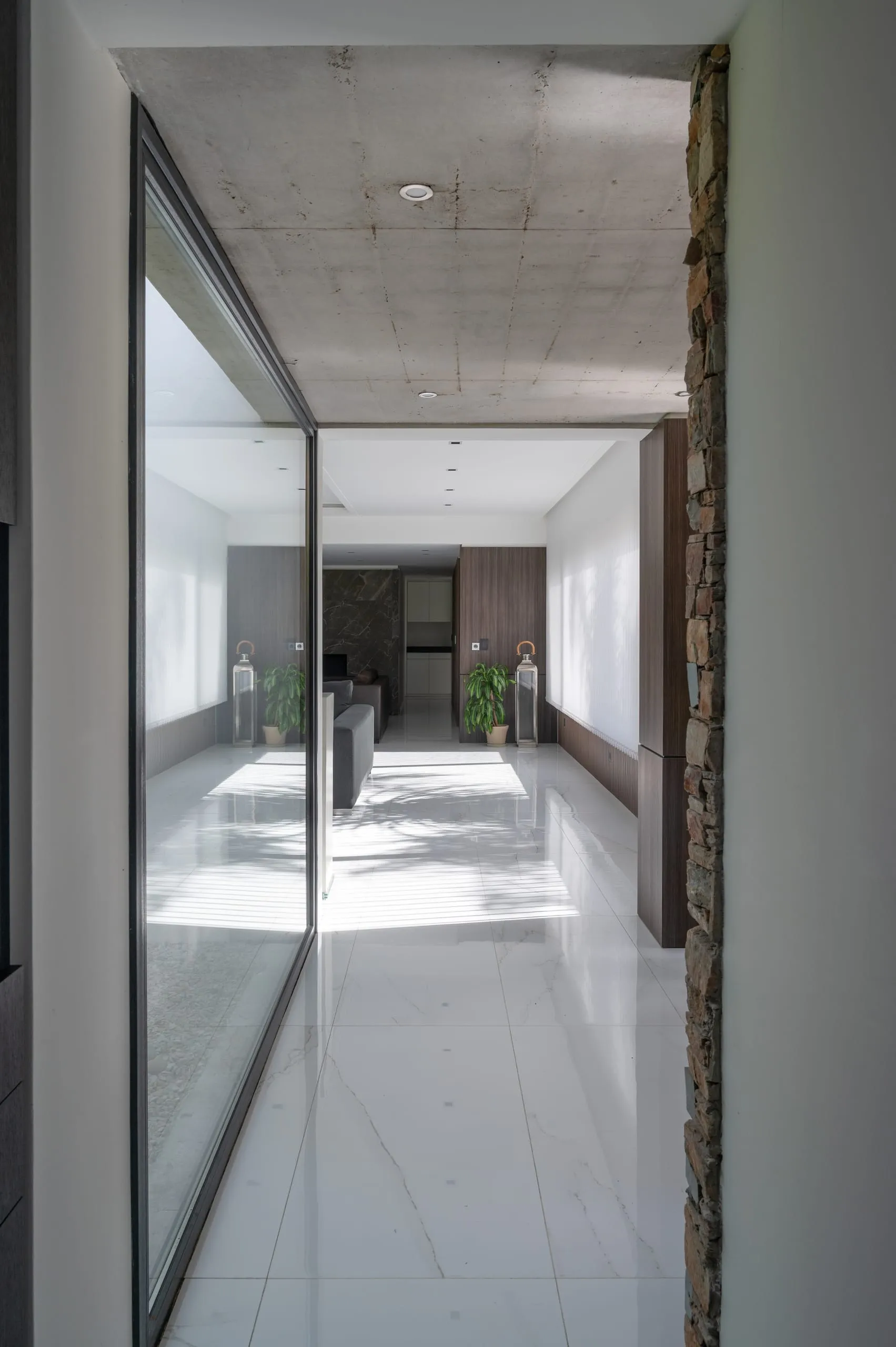 Pasillo vidriado de planta baja con piso blanco