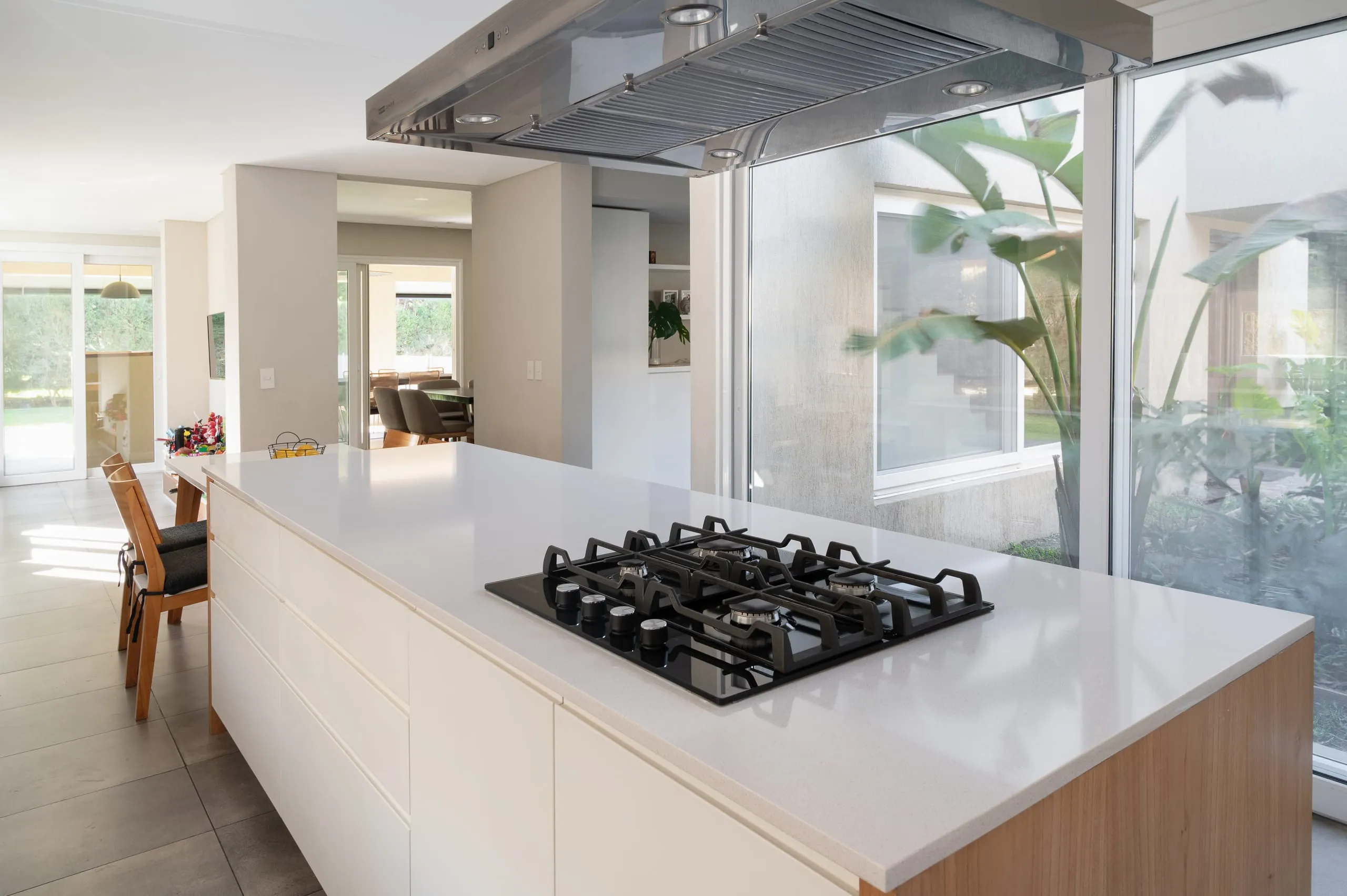 Isla de cocina con anafe y campana, junto al ventanal