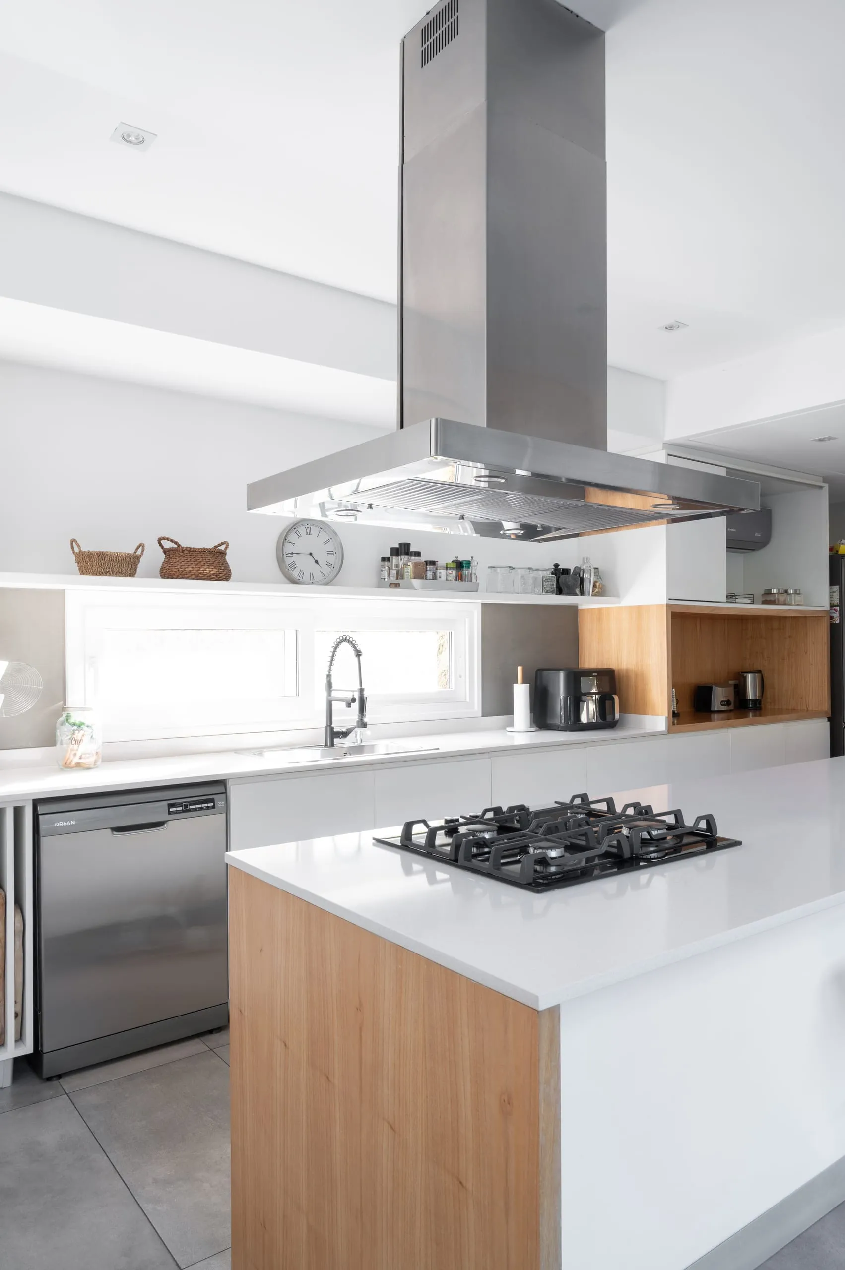 Cocina con isla revestida en madera y campana de acero