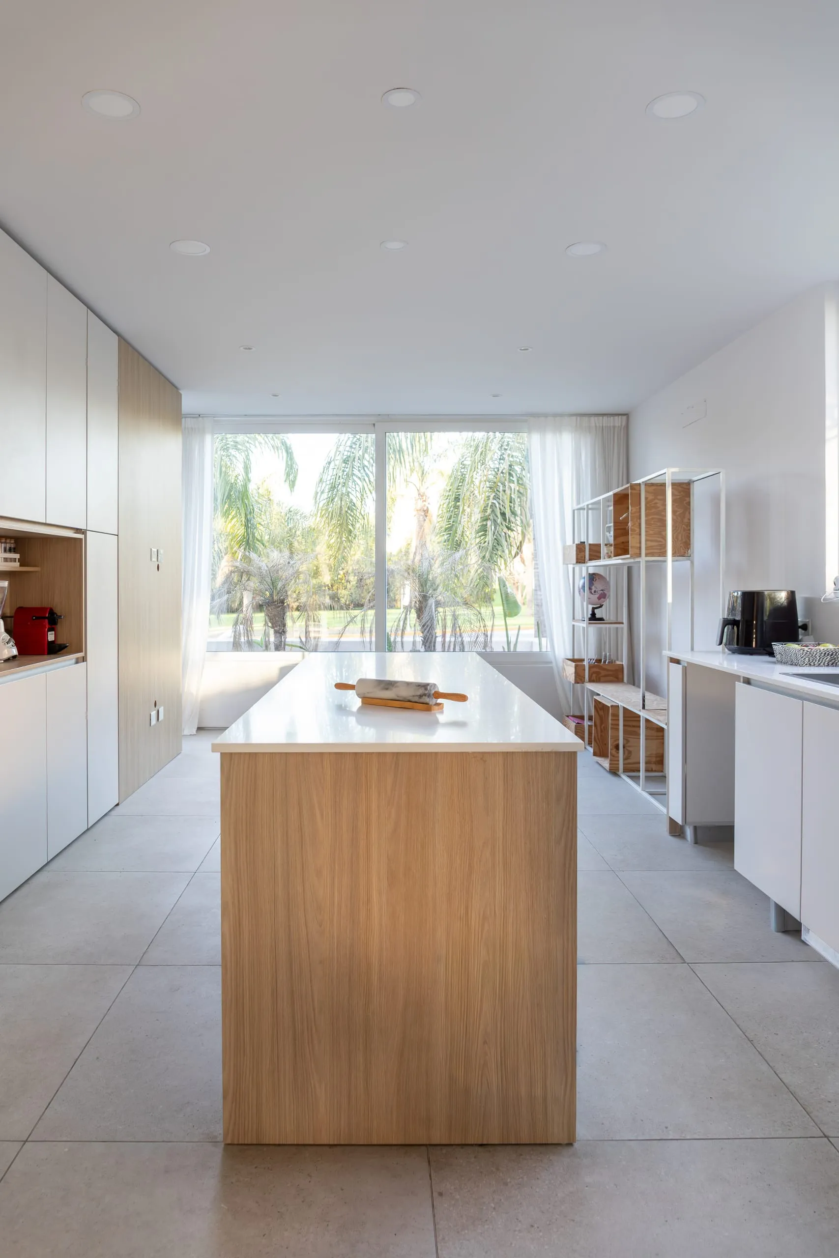 Cocina con isla de madera y ventanal al fondo