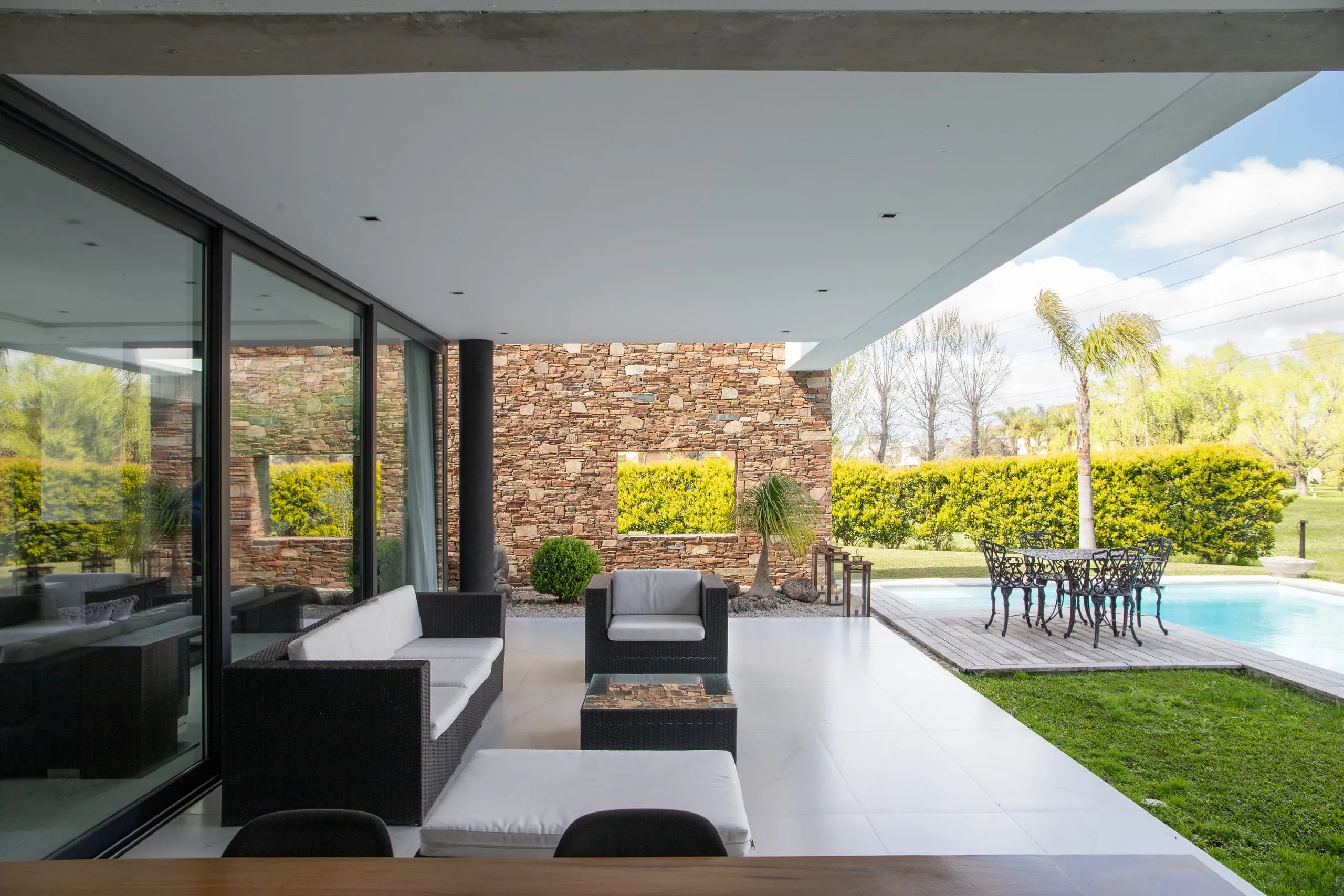 Galería con sillones y vista a la pileta