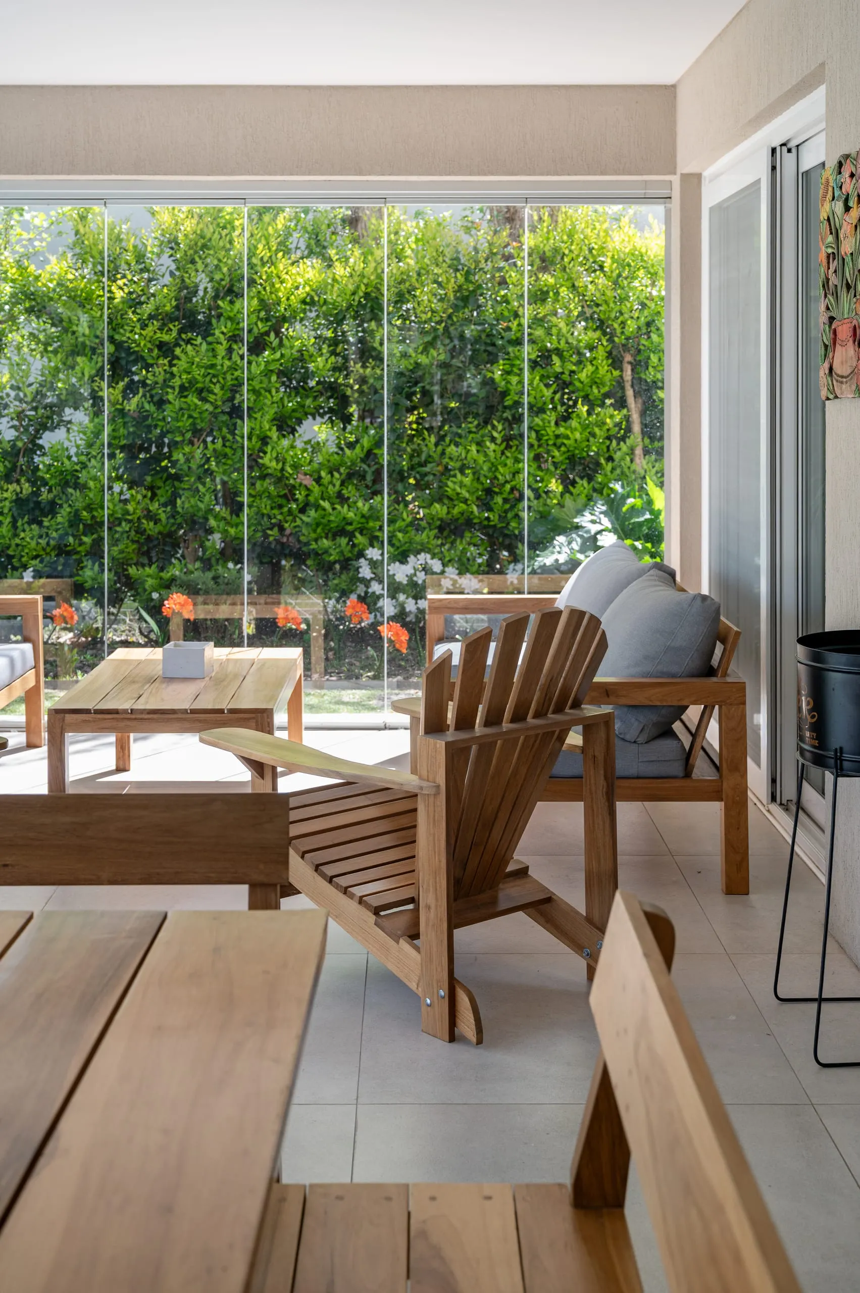 Estar con sillones de madera y ventanal al jardín