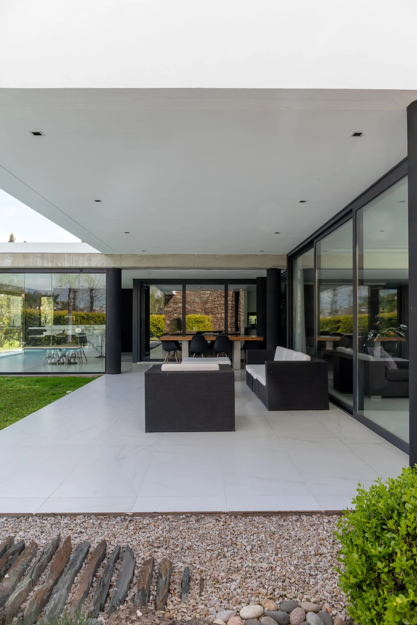 Galería cubierta con sillones y carpinterías vidriadas