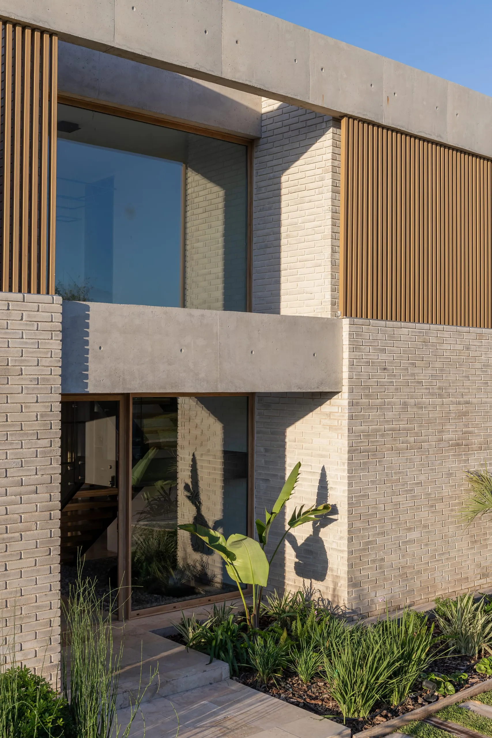 Detalle del frente con parasoles de madera y plantas