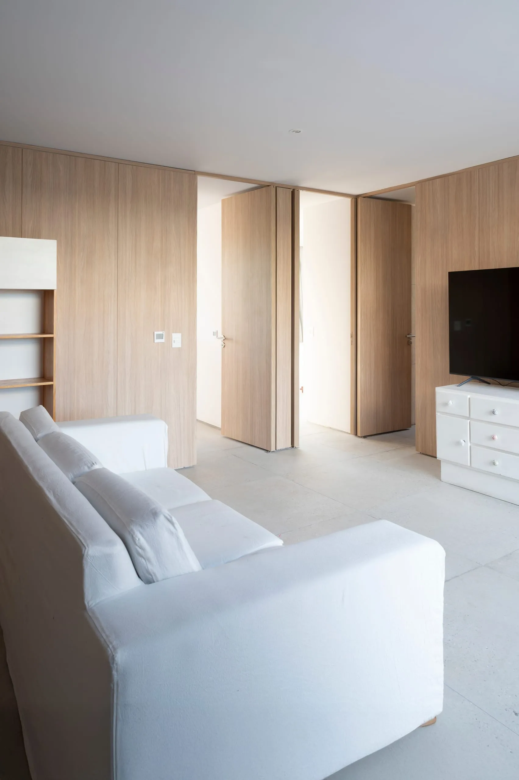 Estar con sillón blanco y muebles de madera