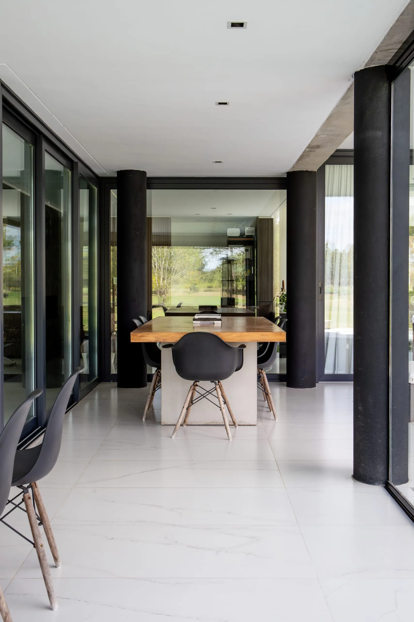 Comedor con mesa de madera y ventanales