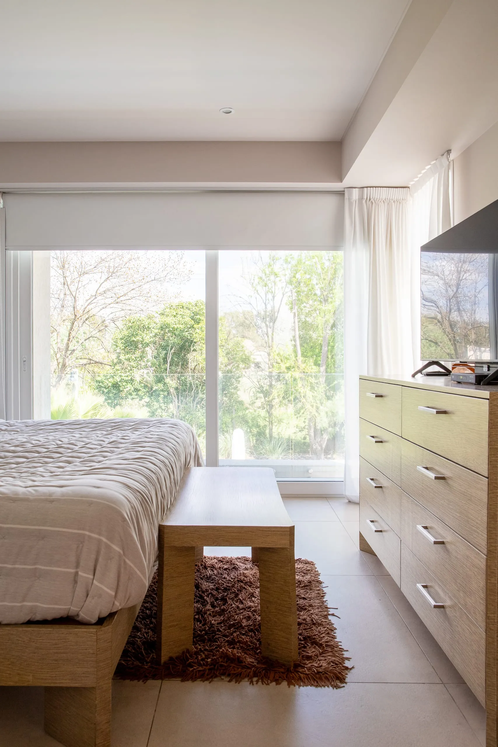 Dormitorio con ventanal hacia el jardín