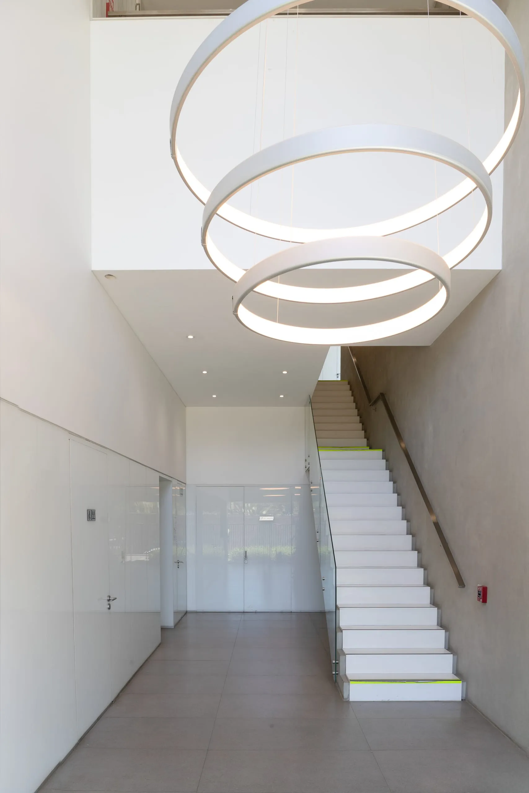 Escalera blanca bajo la lámpara de anillos