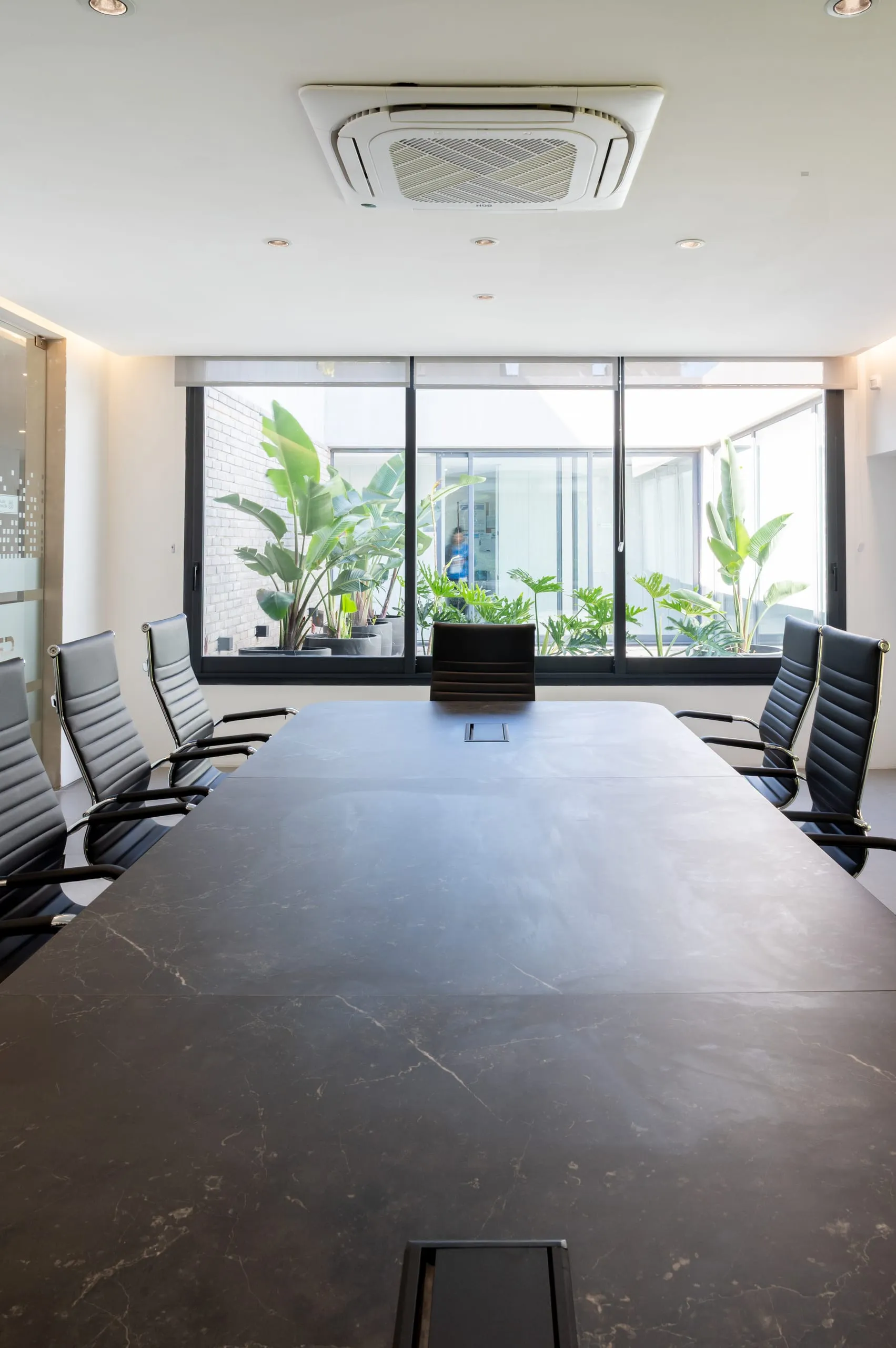 Sala de reuniones con mesa larga y ventanal al jardín