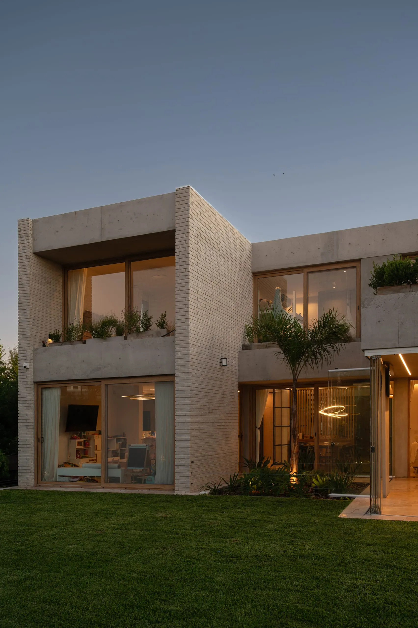Contrafrente al atardecer con la galería y la terraza con plantas