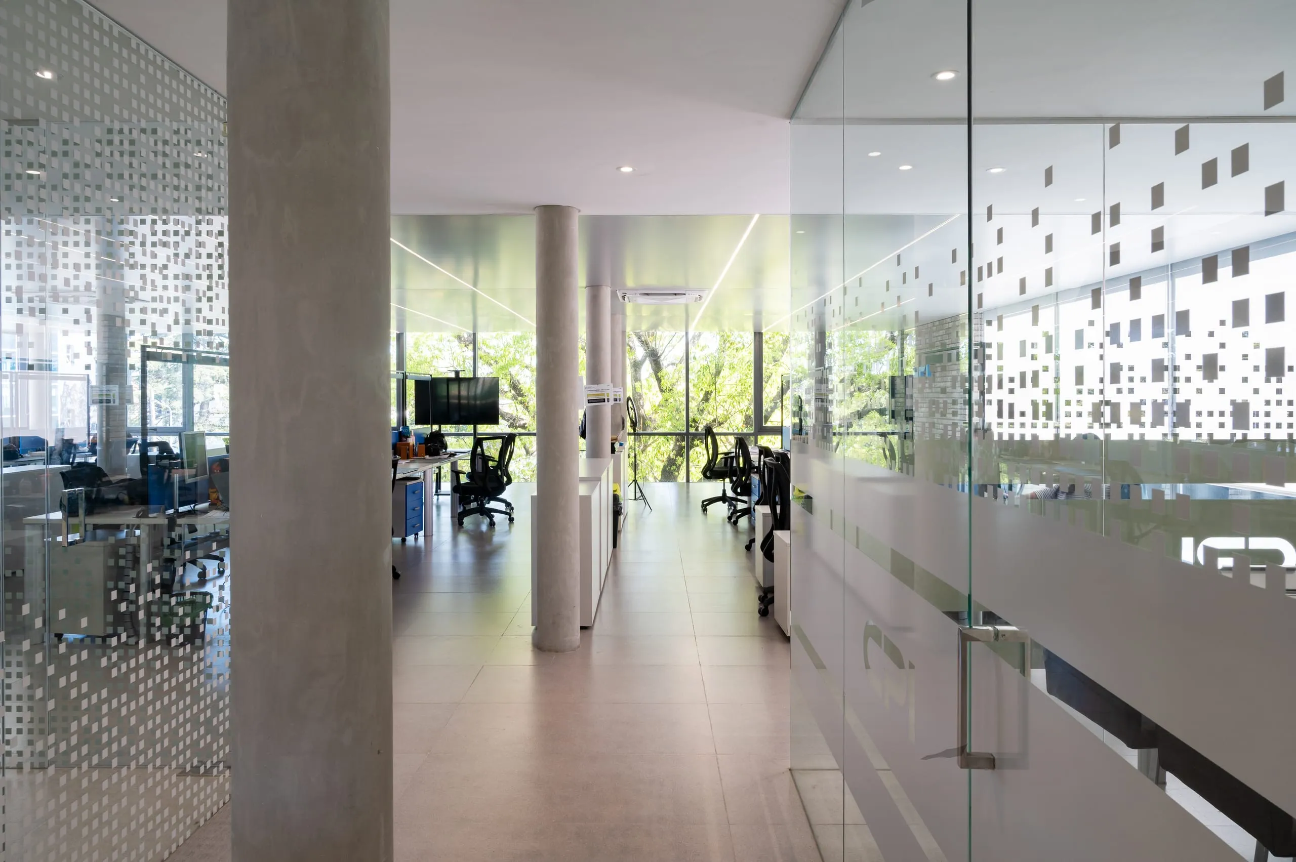 Planta de oficinas con columnas y divisiones de vidrio esmerilado
