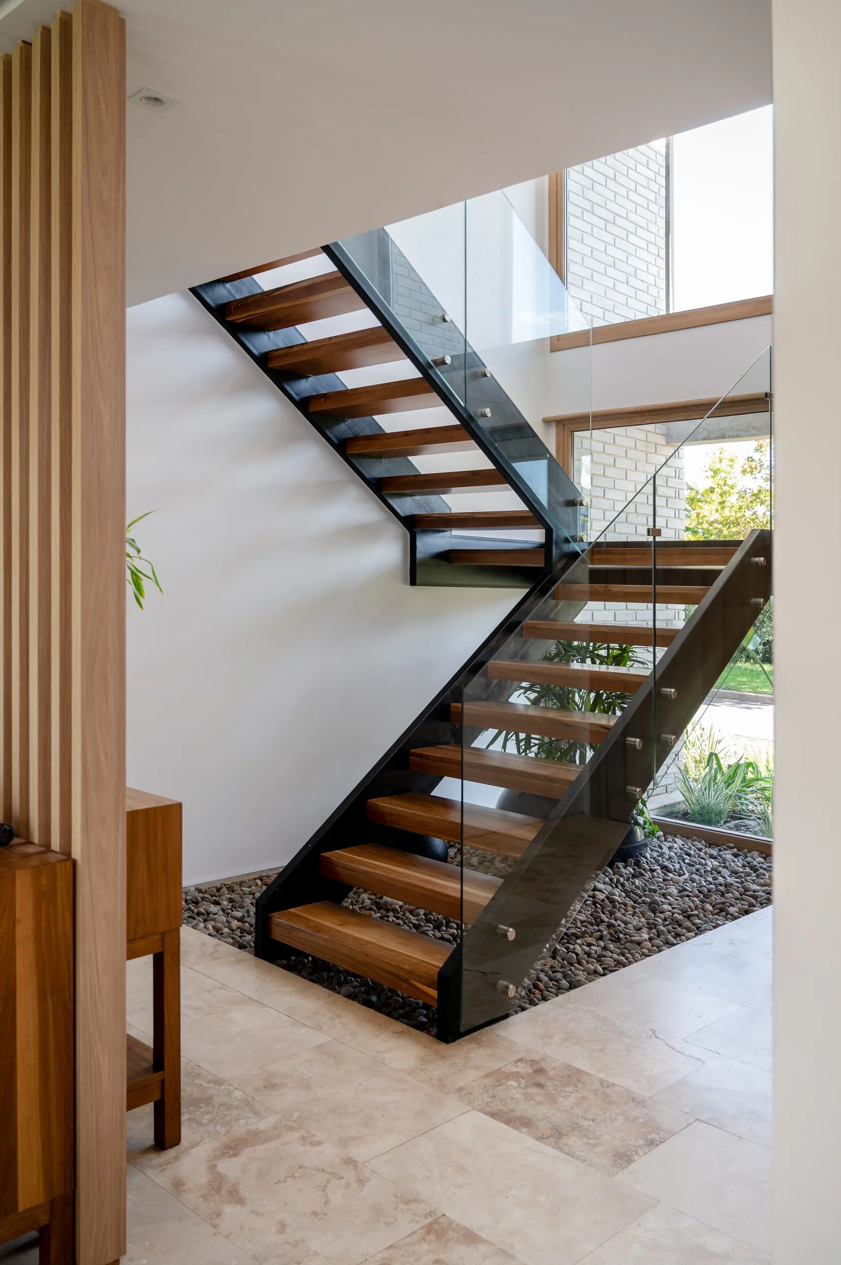 Escalera de madera y hierro junto a un cerramiento de listones